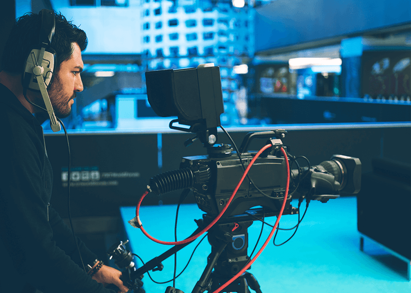 Video camera operator working with his equipment at indoor event