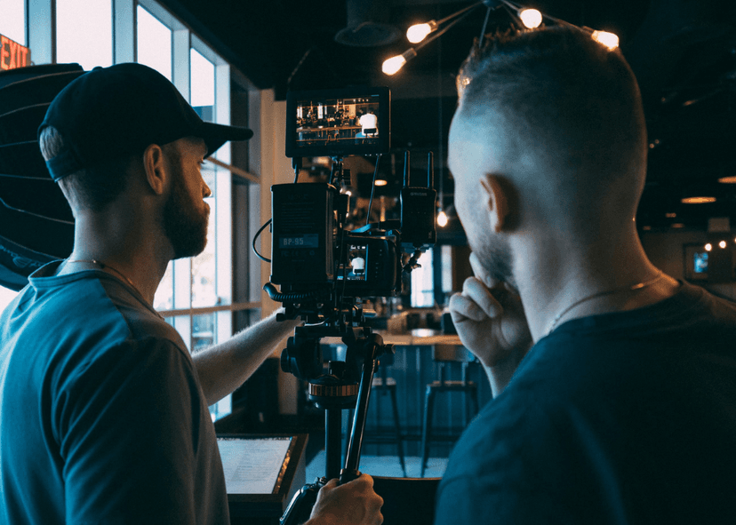 Professional videographer operating broadcast-quality camera equipment for corporate video production